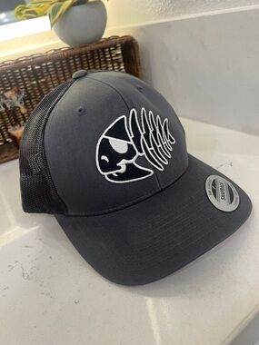 Yupoong Black Mesh Back Trucker Hat with White Fish Skeleton Logo. New